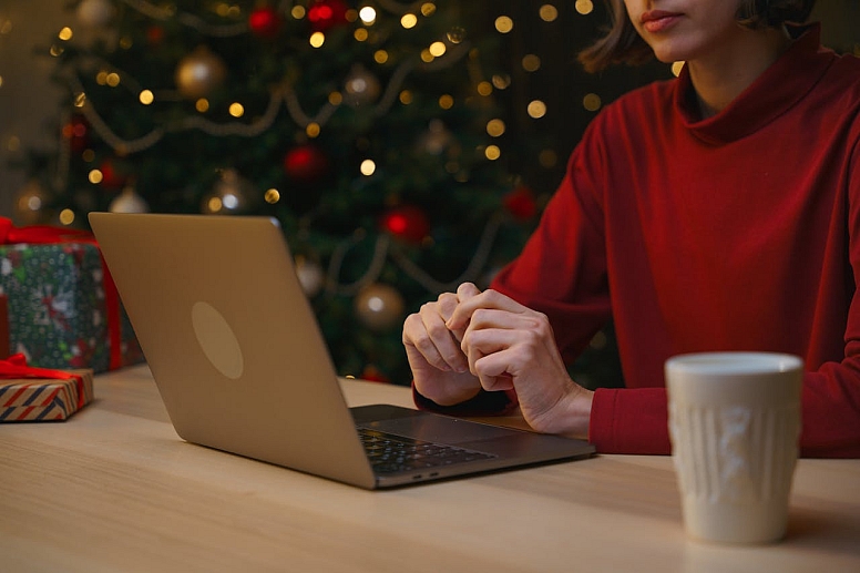 woman sitting at a table and using a laptop